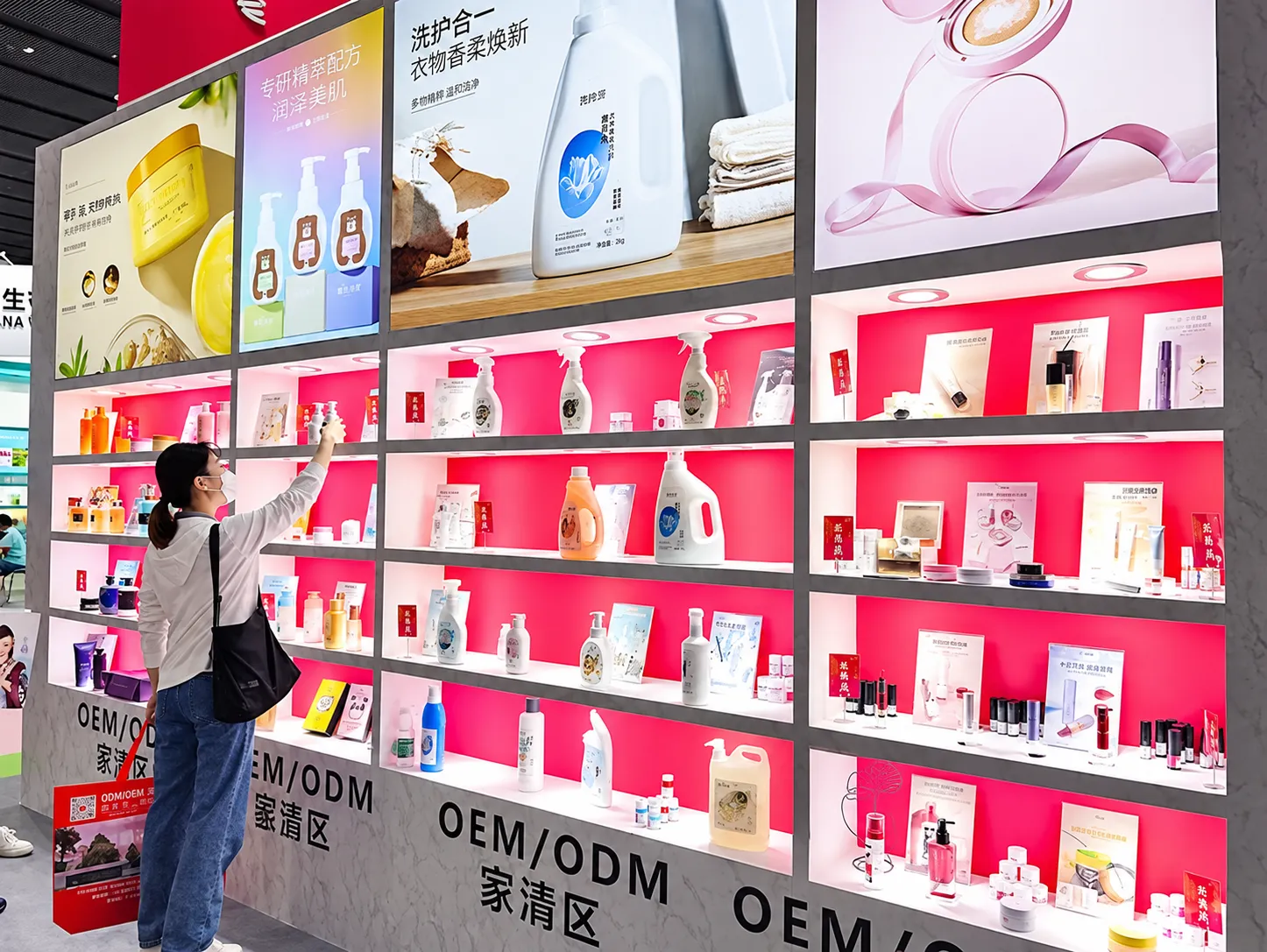 Visitante fotografando produtos de higiene e cuidados pessoais em estande OEM/ODM