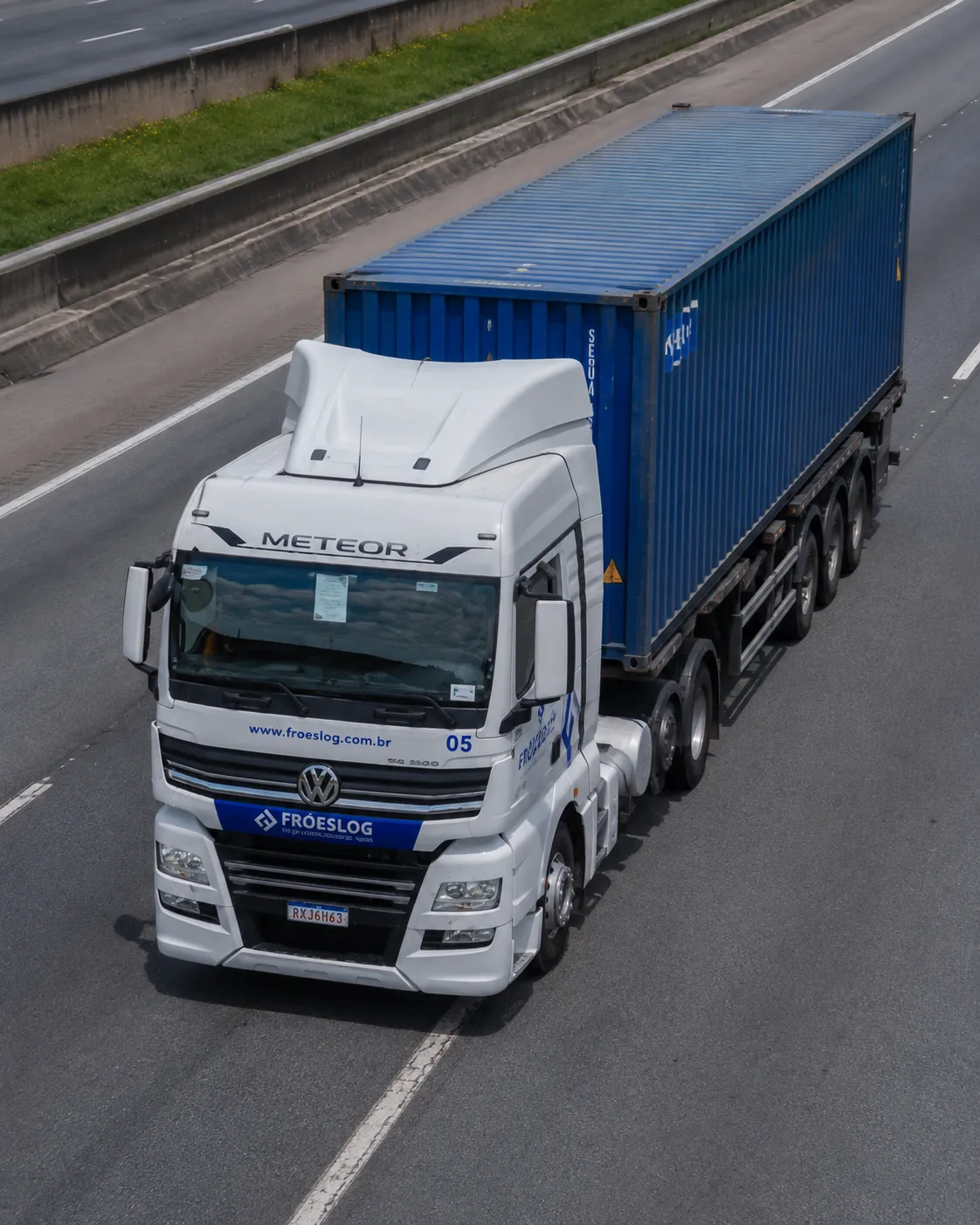 Caminhão FRÓESLOG transportando contêiner em rodovia